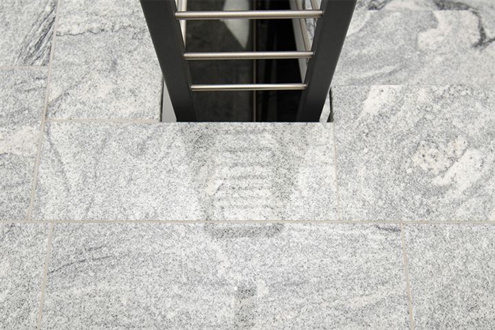 Bodenbelag aus hellgrauem Granit an einer Treppe