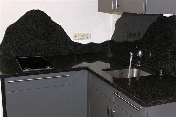 Eine schwarze Natursteinküche mit natürlicher Form.
