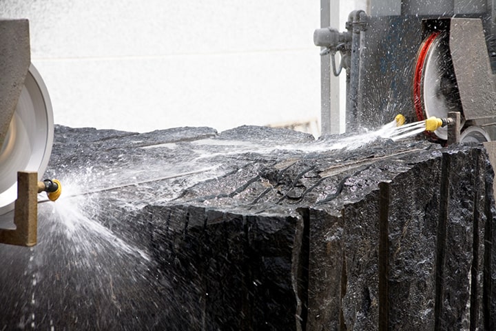 Ein schwarzer Granitblock wird geschnitten.