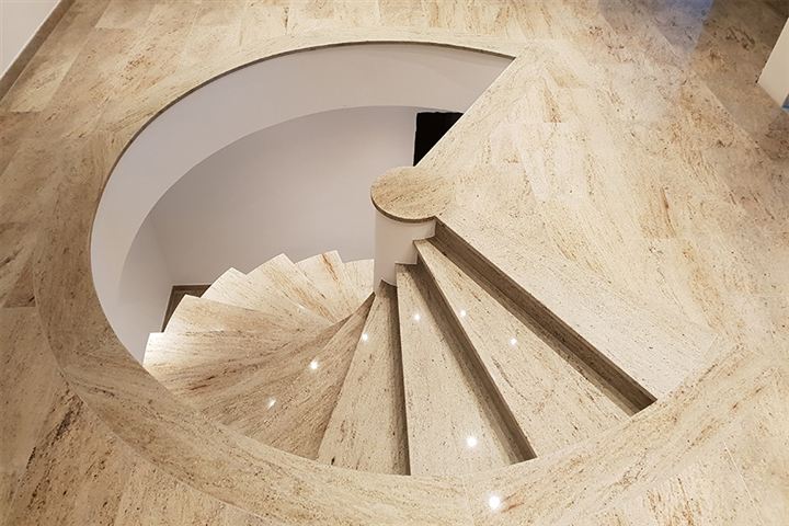 Besondere Natursteinwendeltreppe aus beigefarbenem Stein
