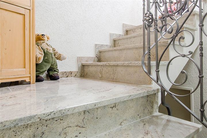 Eine helle Natursteintreppe mit einem Teddybären.